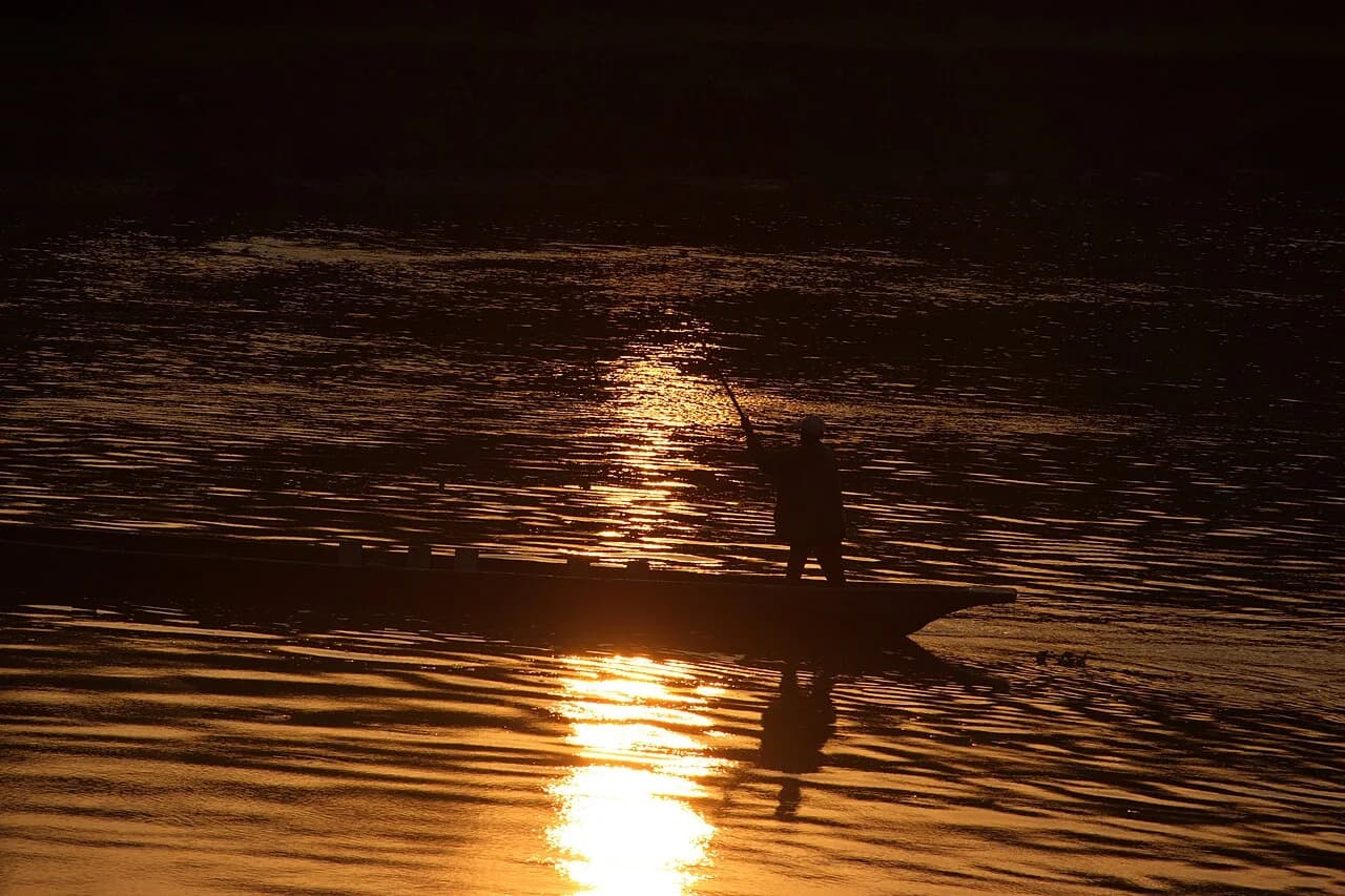 A canoe silhouetted in evening light on the river
