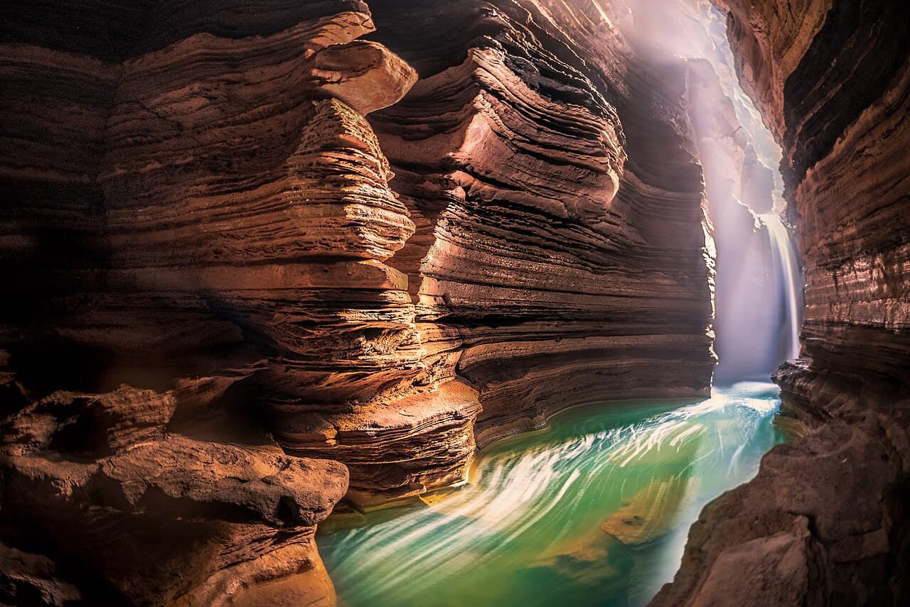Water and layered rock formations inside Gupteshwor Mahadev Cave